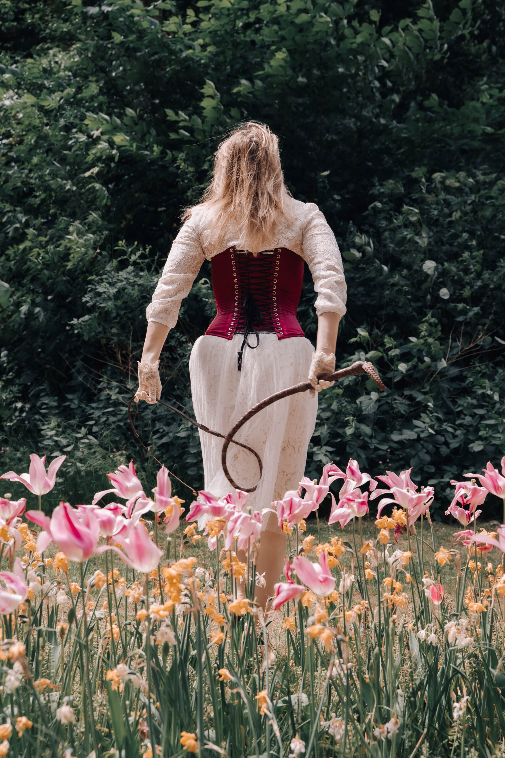Mistress in the Springtime Domina with whip walks through the Luxembourg park flowers